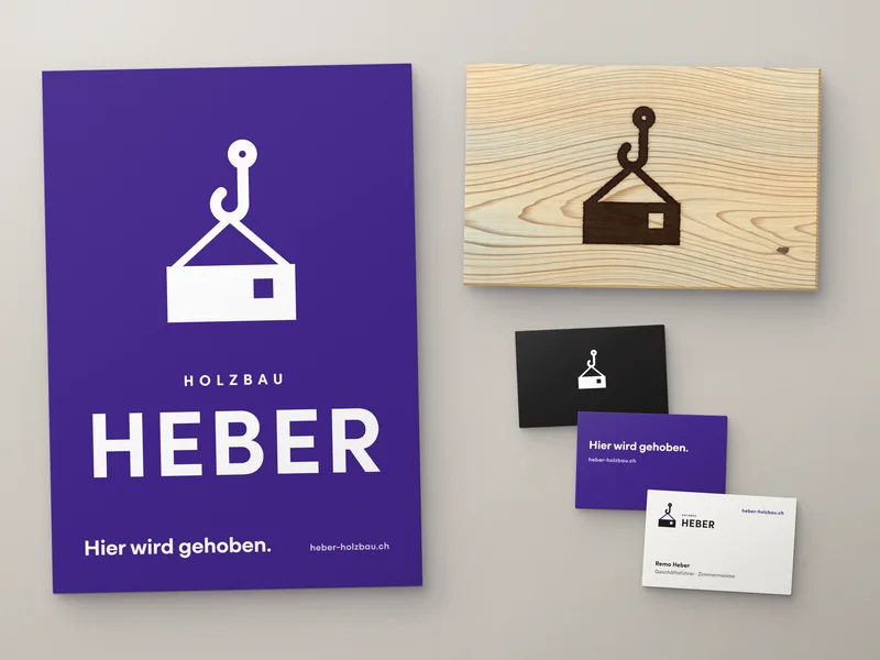 Brand identity for Heber timber construction: purple A4 sheet with crane-hook-and-house mark and wordmark, spruce board with the mark branded into it, and three business cards fanned out.